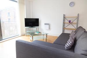 a living room with a couch and a tv at Serviced Apartment in Liverpool City Centre - Free Parking - Balcony - by Happy Days in Liverpool