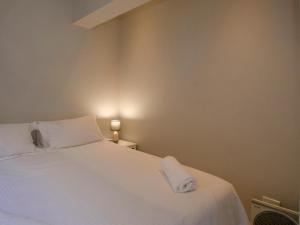ein Schlafzimmer mit einem weißen Bett und einem Handtuch darauf in der Unterkunft 809 Umdloti Beach Resort in Umdloti