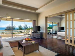 a living room with a room with a view of the ocean at Pullman Phuket Karon Beach Resort in Karon Beach