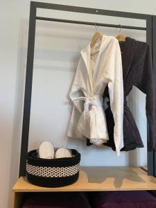 a closet with a rack of clothes and a basket of shoes at La Maison Blanche in Namur +20 photos