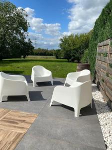 un grupo de sillas blancas sentadas en un patio en La Maison Blanche en Namur