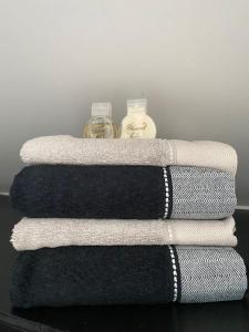 tres toallas sentadas en una mesa con una botella en La Maison Blanche en Namur