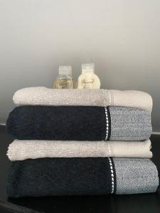 three towels sitting on a table with a bottle at La Maison Blanche in Namur