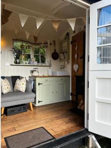 a kitchen and living room with a couch and a table at shepherd hut glamping in Northumberland in Newcastle upon Tyne