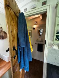a bathroom with a blue towel hanging on a door at shepherd hut glamping in Northumberland in Newcastle upon Tyne