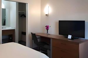 a hotel room with a desk with a television at Inn at Rohnert Park in Rohnert Park