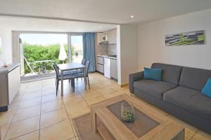 a living room with a couch and a table at CALVI APPART HÔTEL in Calvi