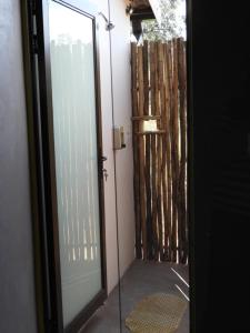 una puerta de cristal que conduce a una puerta con una valla en Newburg Lodge & Luxury Bush Tents, Elements Private Golf Reserve, en Moheme
