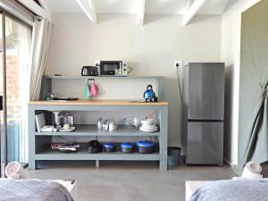 una cucina con frigorifero e mensola con pentole e padelle di Newburg Lodge & Luxury Bush Tents, Elements Private Golf Reserve a Moheme