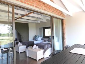 a living room with two beds and a patio at Newburg Lodge & Luxury Bush Tents, Elements Private Golf Reserve in Moheme