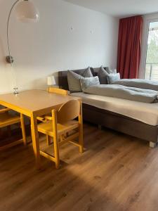 een kamer met een bed en een tafel en een bed en een bank bij Pleskini Apartments in Sankt Englmar