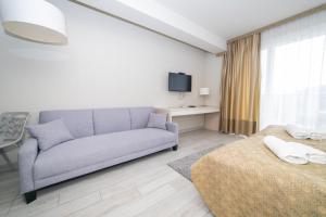 ein Wohnzimmer mit einem Sofa und einem Bett in der Unterkunft VacationClub - Solden Apartament 33 in Heudorf