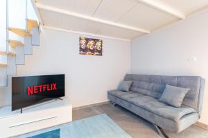 - un salon avec un canapé et une télévision dans l'établissement Exclusive Loft - Life is Beautiful - Free WiFi - 5 min To Metro Nizza, à Turin