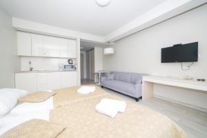 ein weißes Wohnzimmer mit einem Sofa und einem Tisch in der Unterkunft VacationClub - Solden Apartament 33 in Heudorf