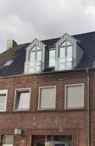 una casa con 3 ventanas en la parte superior de un edificio de ladrillo en Ferienwohnung Seeloft, en Emden