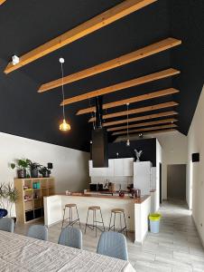 a kitchen with black walls and a counter with stools at Stodoła in Ściegny