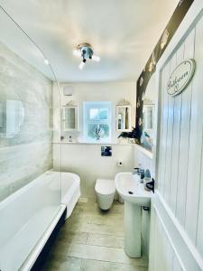 a bathroom with a tub and a toilet and a sink at Cotswold Chic Retreats "Jacinabox" 5 Star Chipping Campden-Parking-Garden in Chipping Campden