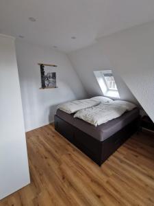 1 dormitorio con 1 cama en la esquina de una habitación en Ferienwohnung Seeloft, en Emden