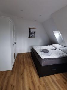 1 dormitorio con 1 cama en una habitación blanca en Ferienwohnung Seeloft, en Emden