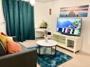 a living room with a couch and a tv at Ocean-homestay in Colchester