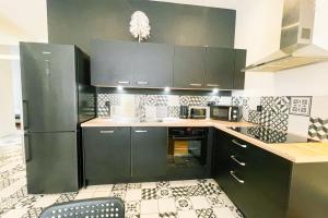 a kitchen with green cabinets and a black refrigerator at Le spacieux de la Gare Large T4 fully equipped Gare de Grenoble #H9 in Grenoble