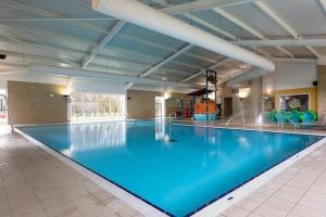 a large swimming pool with blue water in a building at LUXURY CARAVAN 10 mins TO BEACH in Hull