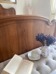une table avec un livre, une tasse et un vase de fleurs dans l'établissement Somlói Provence, à Doba