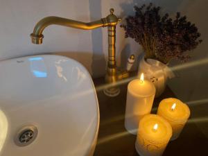 a bathroom sink with two candles and a faucet at Somlói Provence in Doba