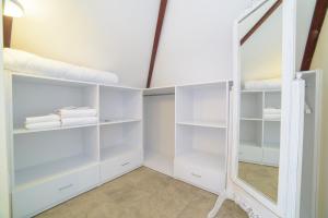 a closet with white shelves and a mirror at Yalicapkini Boutique Hotel in Gulluk