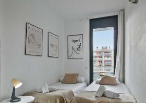 バルセロナにある1213 - Ciutadella Nice Apartmentの壁に絵が飾られた部屋のベッド2台