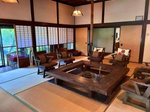 a large living room with a large wooden table and chairs at 洋々庵・古民家一棟貸・完全貸切・プライベートサウナ in Furuyu