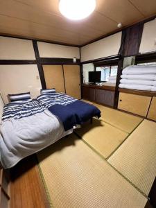 1 dormitorio con 1 cama en el centro de una habitación en 洋々庵・古民家一棟貸・完全貸切・プライベートサウナ en Furuyu