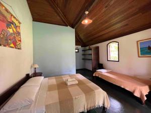 a bedroom with two beds in a room at Casinha Jardim das Palmeiras in Morro de São Paulo