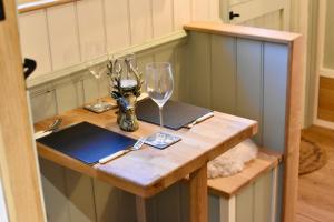 a table with a wine glass and a laptop on it at The Deer Hut in Burpham