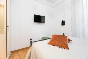 a bedroom with a bed with a television on the wall at Lungotevere Testaccio Apartment in Rome