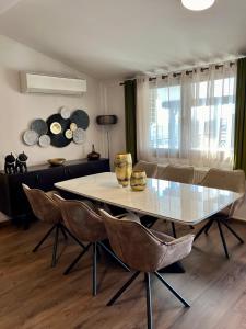 uma sala de jantar com uma mesa branca e cadeiras em ZEN Apartments em Alexandroúpolis
