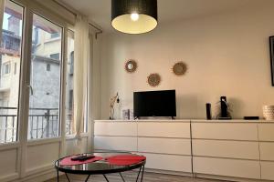 uma sala de estar com uma televisão e uma mesa de centro em Le Saint François Hypercentre #AR em Grenoble