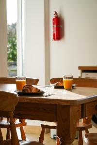 a table with a plate of food and two glasses of orange juice at The Birdhouse Family Home with Countryside Views in Beal