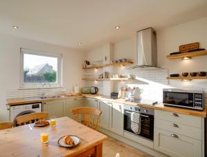 a large kitchen with a wooden table and a wooden tableablish at The Birdhouse Family Home with Countryside Views in Beal