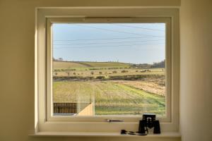 a window with a view of a field at The Birdhouse Family Home with Countryside Views in Beal