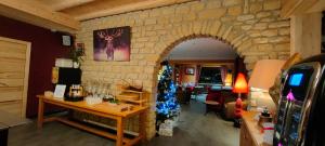 a living room with a christmas tree in a stone wall at Logis Hotel Les Playes in Villard-de-Lans