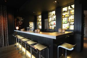 Eine Bar mit Hockern in einem Raum mit Fenstern in der Unterkunft Hotel Hogerhuys - adults only in Noordwijk aan Zee + 32 Fotos