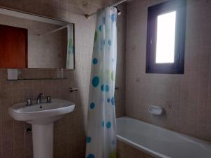 a bathroom with a sink and a shower curtain at Hosteria Olimpo in Villa Gesell +17 photos