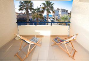 d'un balcon avec deux chaises et une vue sur les palmiers. dans l'établissement T2 Écume Vue Mer Terrasse Parking, à Palavas-les-Flots