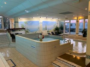 a large building with a swimming pool in the middle at Pleskini Apartments in Sankt Englmar
