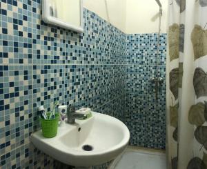a blue tiled bathroom with a sink and a shower at Room in Agadir Morocco in Agadir