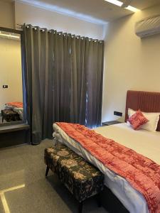 1 dormitorio con 2 camas y una ventana con cortinas en A M Suites en Tohāna