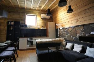 uma sala de estar com um sofá e uma parede de pedra em Holiday House with garden and sauna em Durness