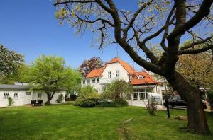 uma grande casa branca com um telhado laranja em Strandvilla Rheingold - Nebengebäude em Göhren
