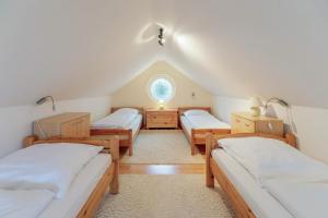a attic room with three beds and a window at Heidehaus in Enge-Sande